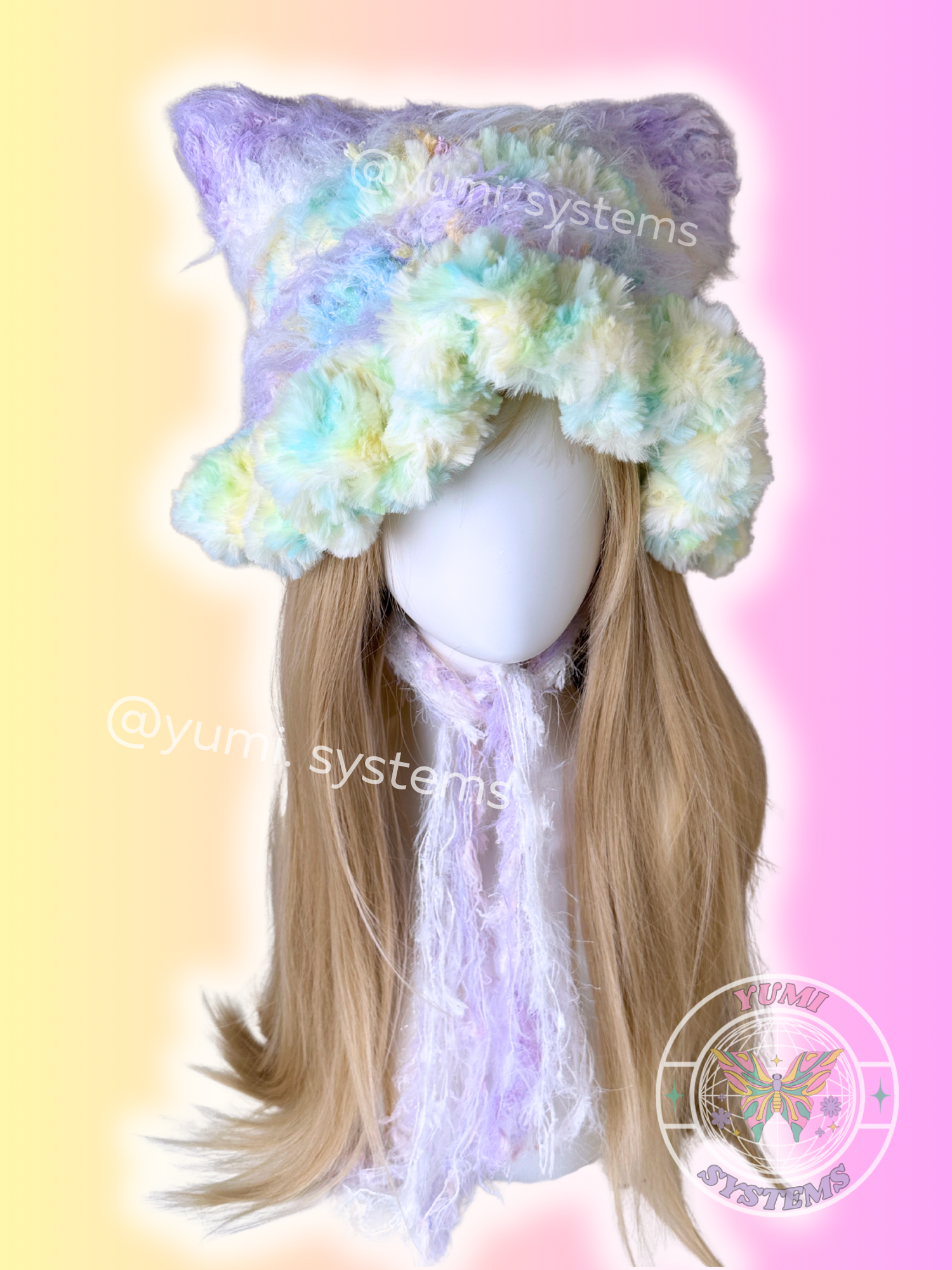 Close-up of a thick, handmade purple and grey cat ear beanie with long fuzzy streamers on a mannequin.